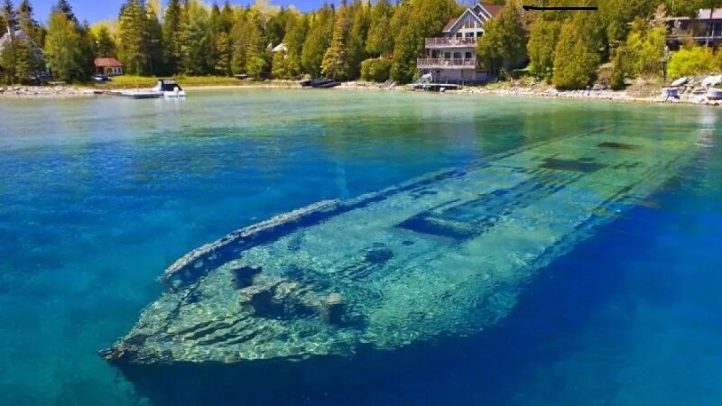 Sunken barge under blue water.