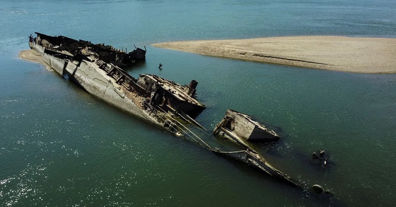 A ruined ship semi-submerged underwater.