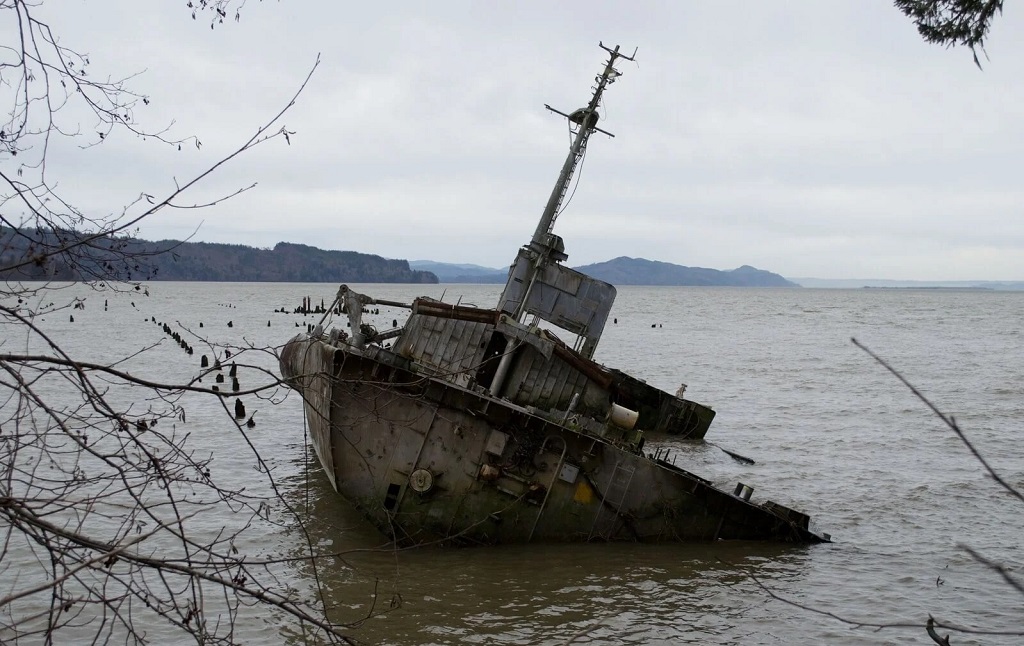 Submechanophobia: a rusty old boat sinking into water.