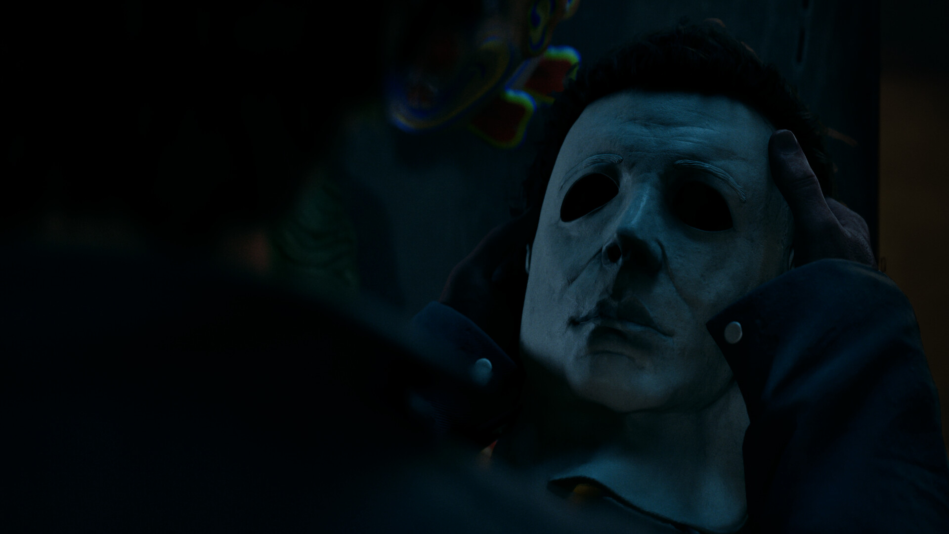Halloween The Game: a dark image showing a pair of hands holding Michael Myers' iconic white mask.